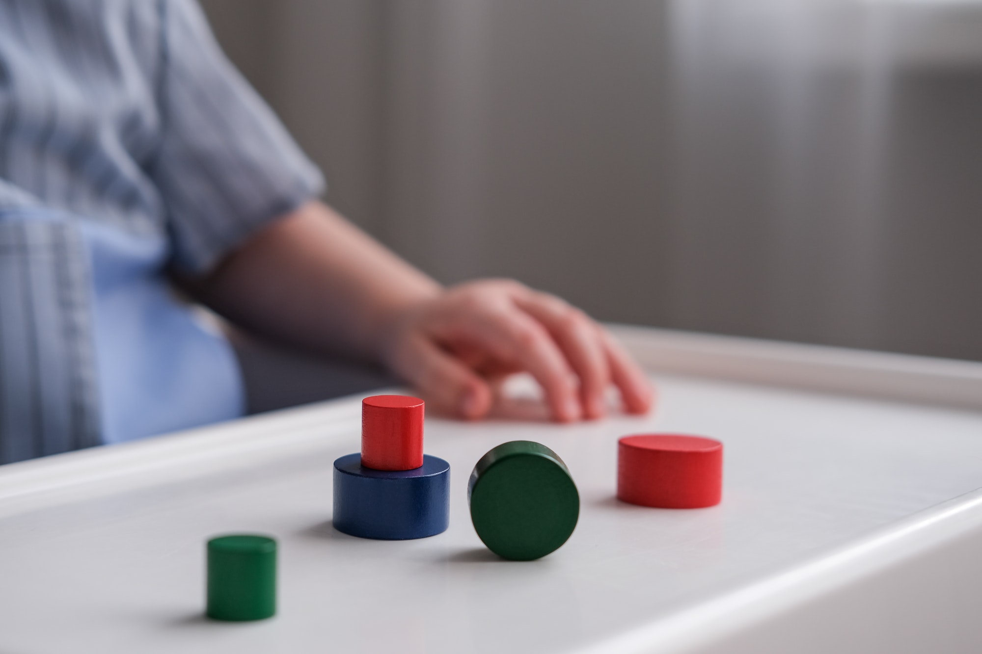 One year old child plays with wooden figurines